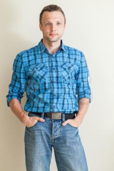 Young Caucasian man in blue checkered shirt and jeans