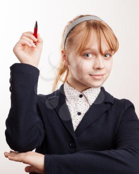 Little blond schoolgirl holds up the pen
