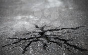 Closeup photo of natural cracks on old asphalt road
