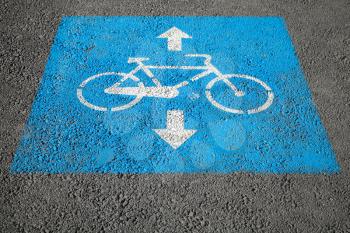 Bicycle lane. Blue and white road marking over urban asphalt road