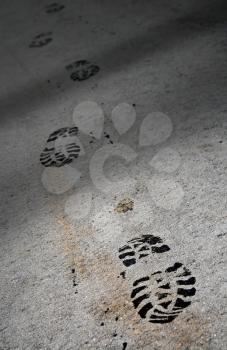 Closeup photo of a footprints on the dark asphalt
