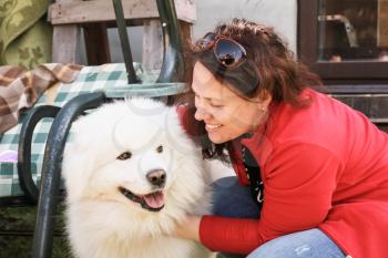 Happy young Caucasian woman and white fluffy Samoyed dog