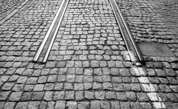 The end of tramway railroad in the city, stone pavement and rails perspective