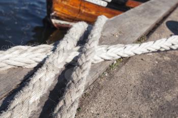 Nautical ropes used for mooring operations lay on the pier, closeup photo with selective focus