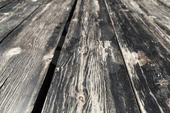 Grungy old black wooden floor background texture with perspective effect and selective focus