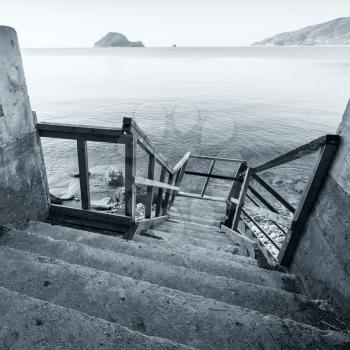 Wooden stairs on the sea coast. Square blue toned coastal seascape of Zakynthos island, Greece