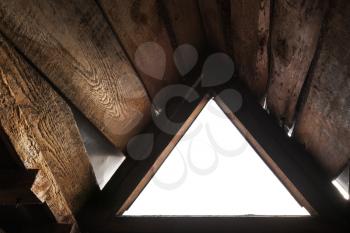 Empty triangle window with white background in old grunge wooden interior