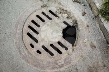 Old damaged round sewer manhole cover