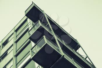 Abstract contemporary architecture fragment, walls and balconies made of glass and concrete. Green tonal correction filter effect