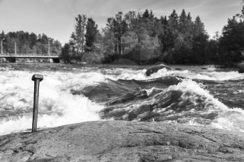 Langinkoski, fast running river water in Kotka, Finland. Black and white natural photo