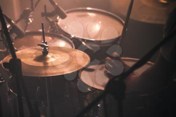 Warm vintage toned musical photo background, drummer plays on rock drum set