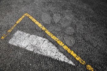 Road marking, white stripe and corner of yellow borders line over black asphalt pavement, background photo