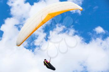 Amateur paraglider flying in cloudy sky
