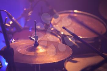 Warm toned live music photo background, drummer plays on rock drum set. Close-up photo, soft selective focus