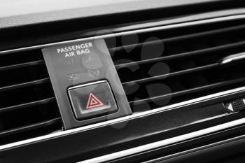 Emergency stop button with red tiangle sign, modern black car interior details