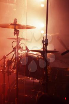 Live rock music background, rock drum set. Warm toned closeup vertical photo, soft selective focus
