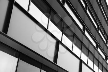 Modern industrial building facade abstract fragment, shiny windows in steel structure, black and white