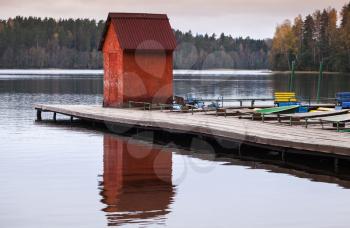 Small red barn on floating pier with moored boats, Karelia, Russia