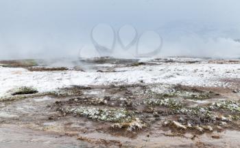Boiling geyser water in southwestern Iceland, foggy winter day