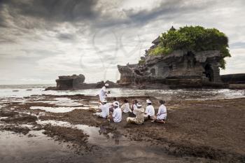 BALI, INDONESIA - APRIL 02: Balinese pilgrims at Tanah Lot temple on April -2, 2011, Tanah Lot, Bali. The temple has been part of Balinese mythology for centuries. 