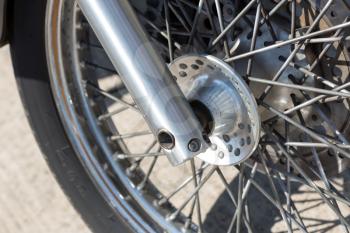 Detail of the front wheel of a motorcycle with spokes