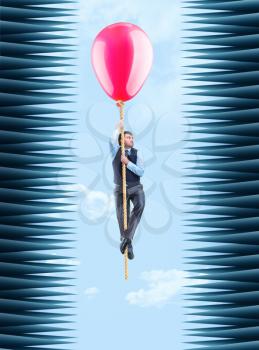 Businessman hanging on the rope with a big ballon in a thorny tunnel