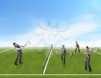 Businessman and businesswomen playing tennis outside