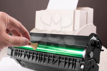 Technician hand cleaning printer toner cartridge