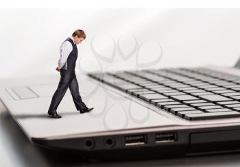 Businessman walks on laptop while thinking