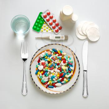 Medical dinner set with silverware and pills