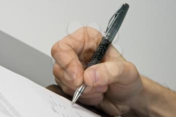 Man's hand signing the document