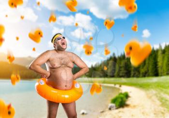 Strange naked man with children's buoy and falling ducks on nature