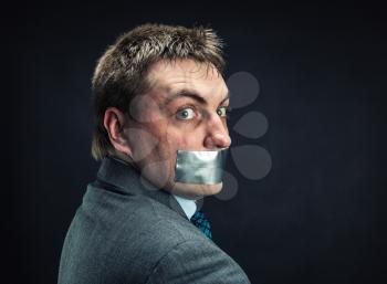 Man with mouth covered by masking tape ,studio shoot