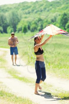 Happy couple flying a kite in a summer day