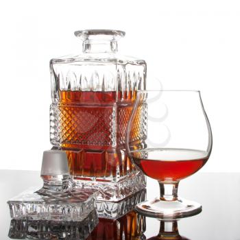 Decanter and glass of wealth cognac on mirror