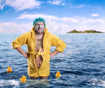 Crazy man with face pack stands in water