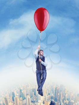 Businessman flying on the big ballon above the city