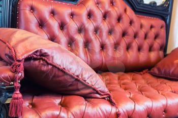 Close up of luxuroius leather-covered sofa with a pillow