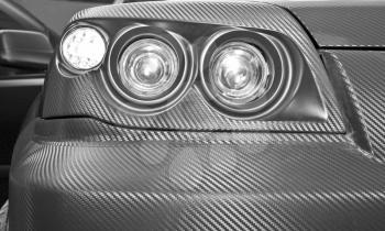 Futuristic carbon car headlight. Closeup