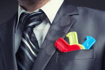 Businessman with colorful toy keys in suit pocket