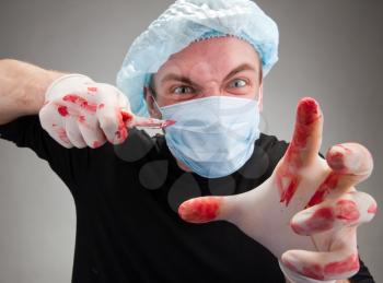 Mad mental sick blood soiled surgeon with knife