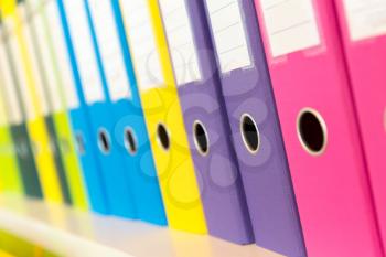 Colorful folders standing on the shelf in the office