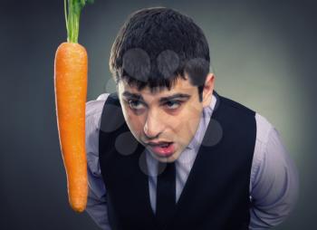 Bait metaphor. Man looking at carrot