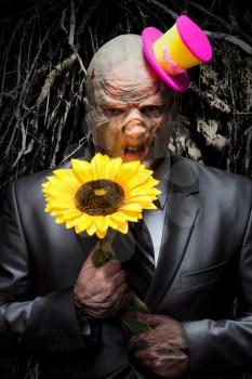 Sad monster in business suit with sunflower