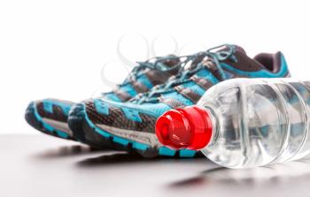 Closeup of blue sports runners and a bottle of water