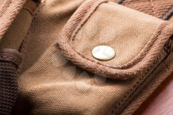 White button on small brown pocket