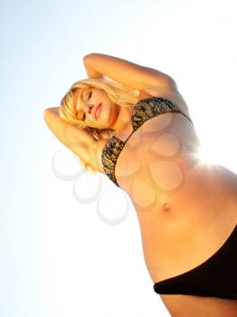 Smiling tan bikini blonde by sunlight