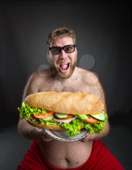 Fat happy man in glasses with sandwich