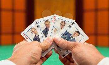 Businessmen playing poker with business team cards