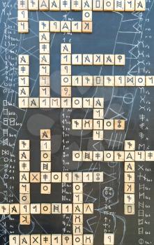 Hieroglyphes on crossword puzzle against abstract background
